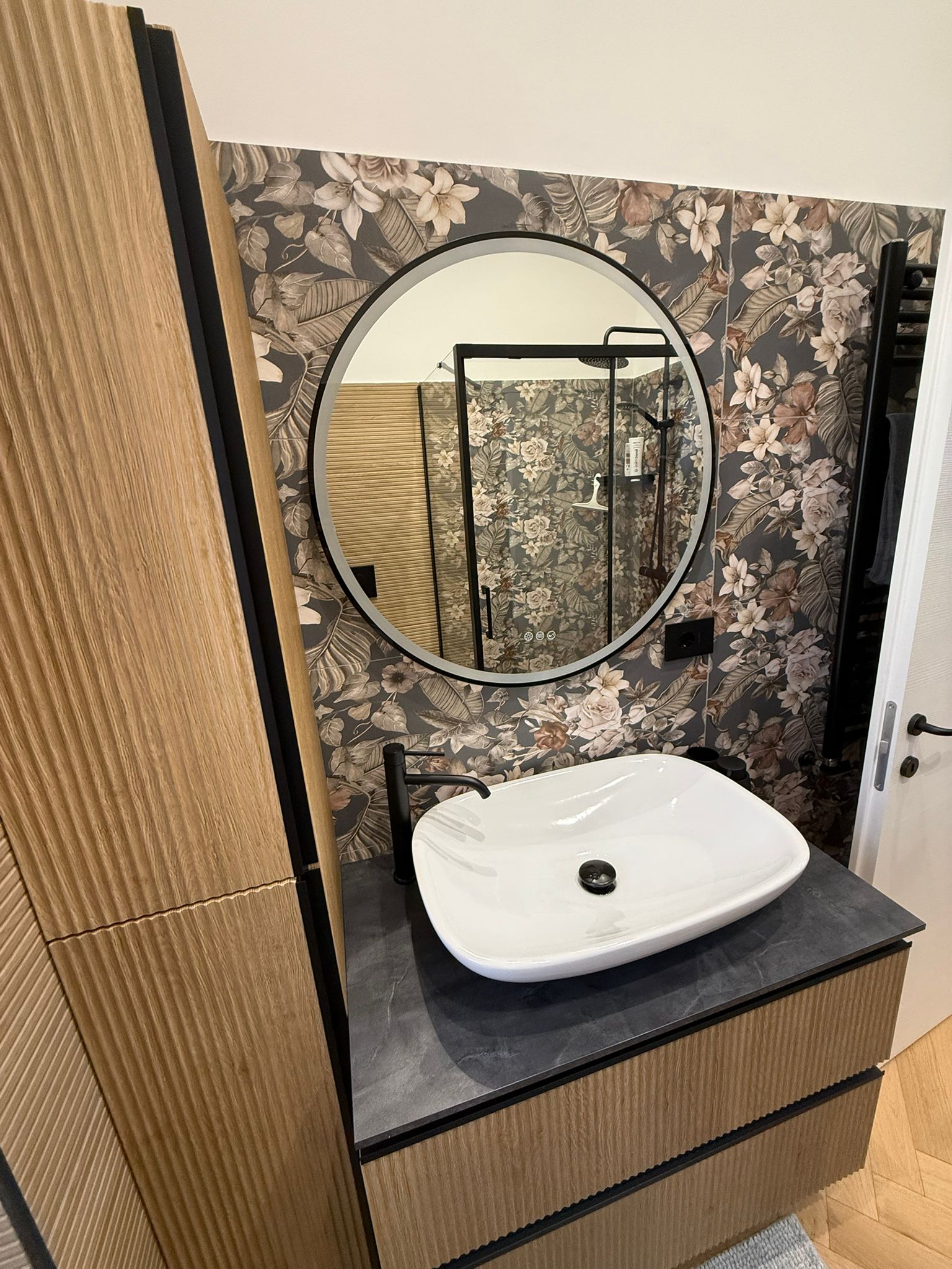 Bagno moderno con piastrelle chiare e specchio retroilluminato