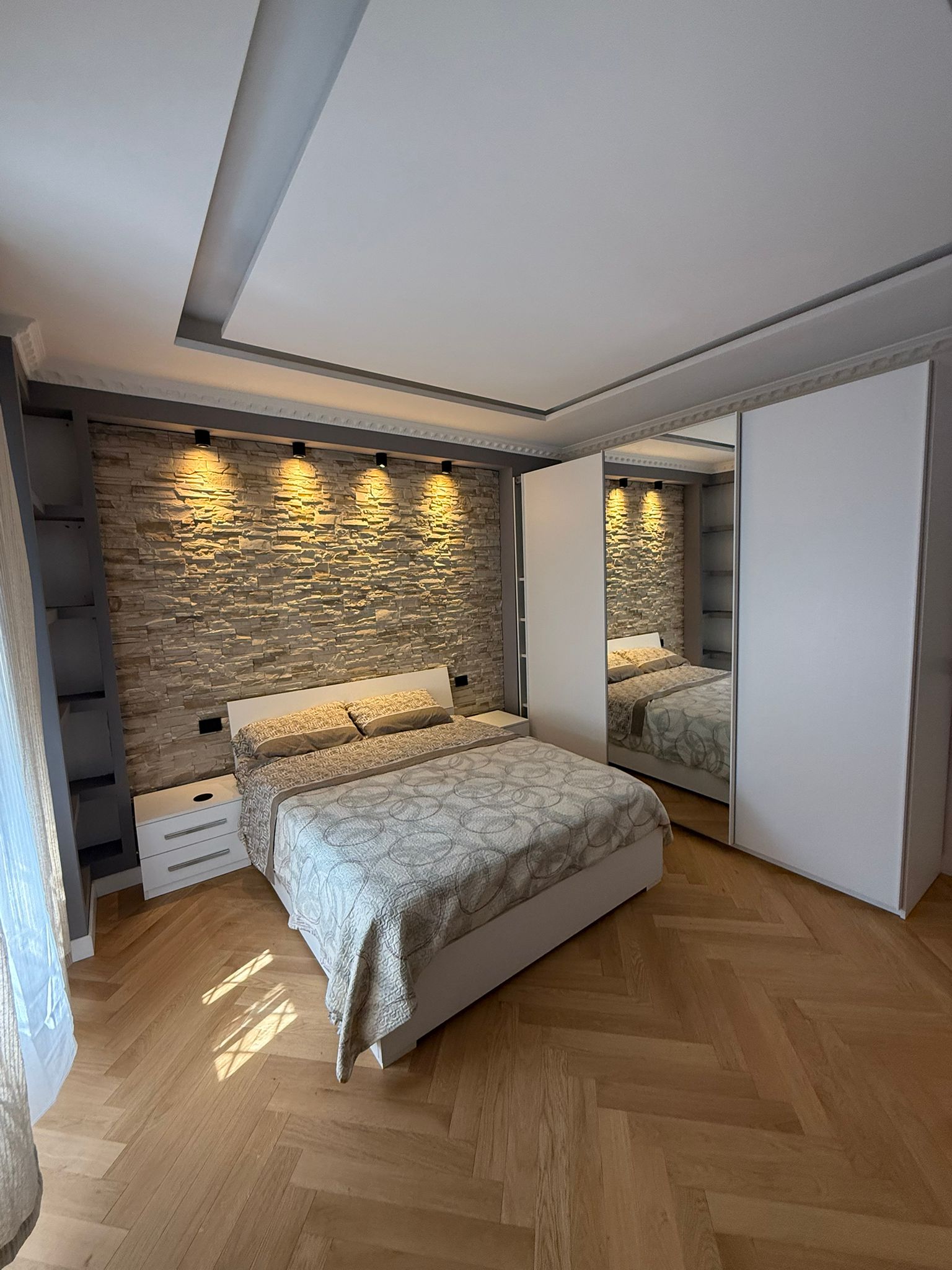Letto con parette effetto cemento e farretti superiori per massima eleganza.
